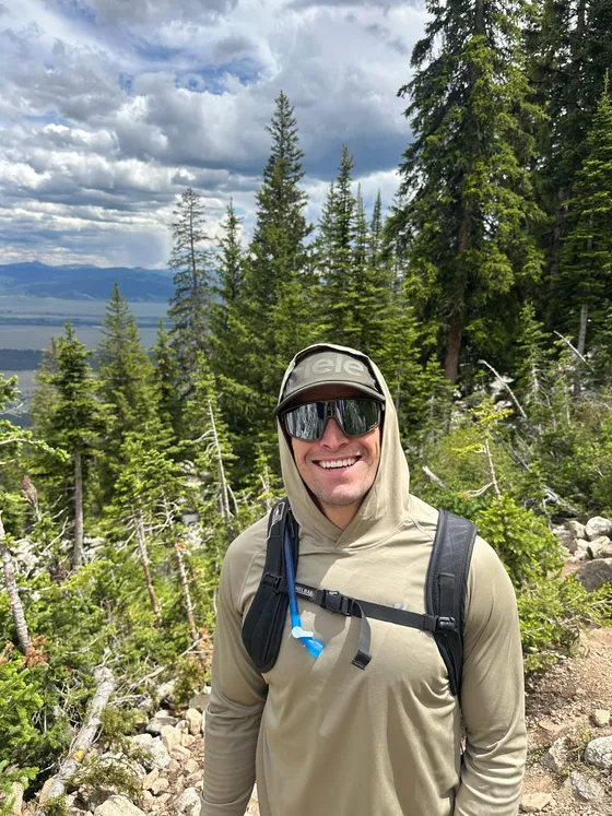 Zack in a hooded sun shirt on a trail above Jackson Hole